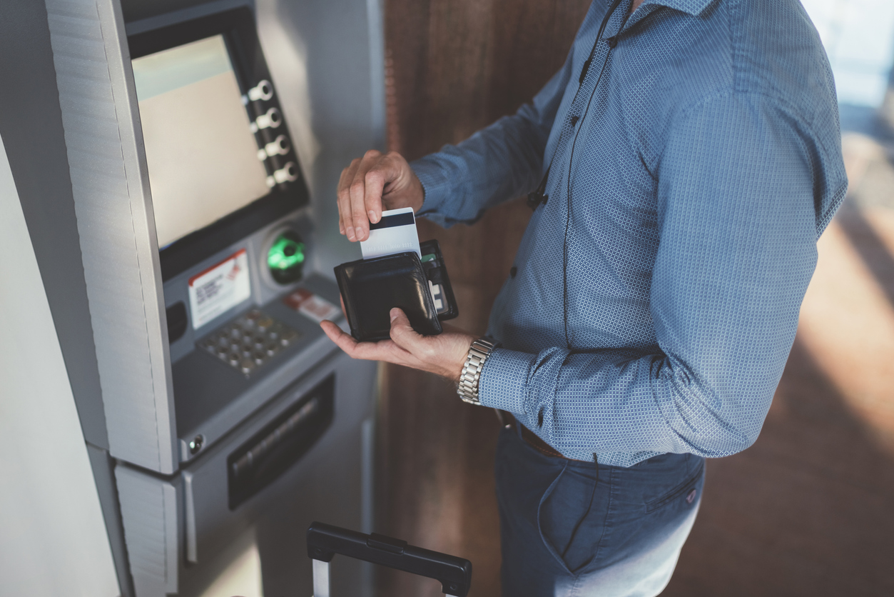 Passeggero che utilizza la carta di credito al bancomat dell'aeroporto